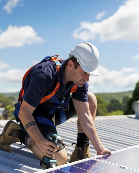 Male solar technician installing panel