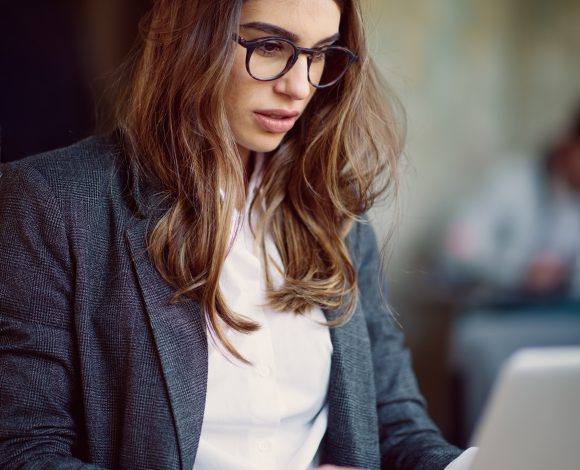 Caucasian female web designer on laptop