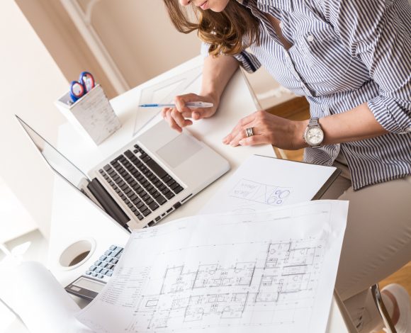 Caucasian female drafter at desk on laptop