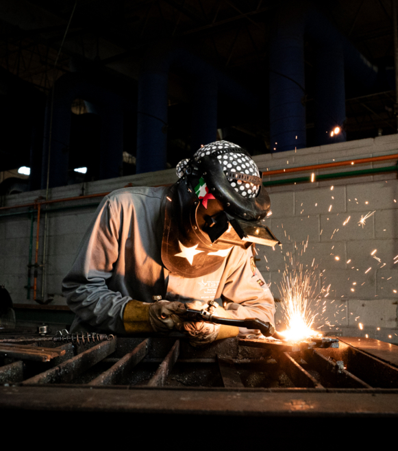 a man welding metal with sparks