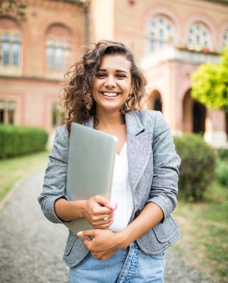 Caucasian female student holding laptop