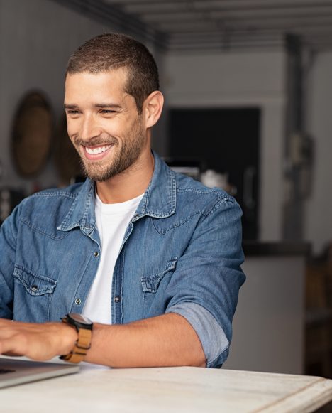 Caucasian male smiling on laptop | Loans