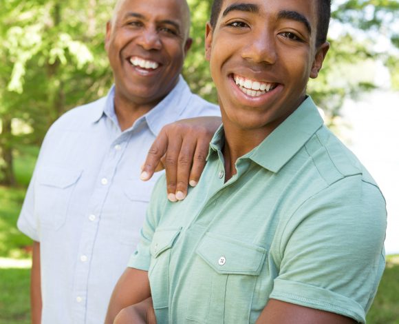 Black teen with father smiling