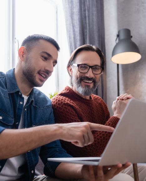 Hispanic male at laptop with father | Consumer Guide