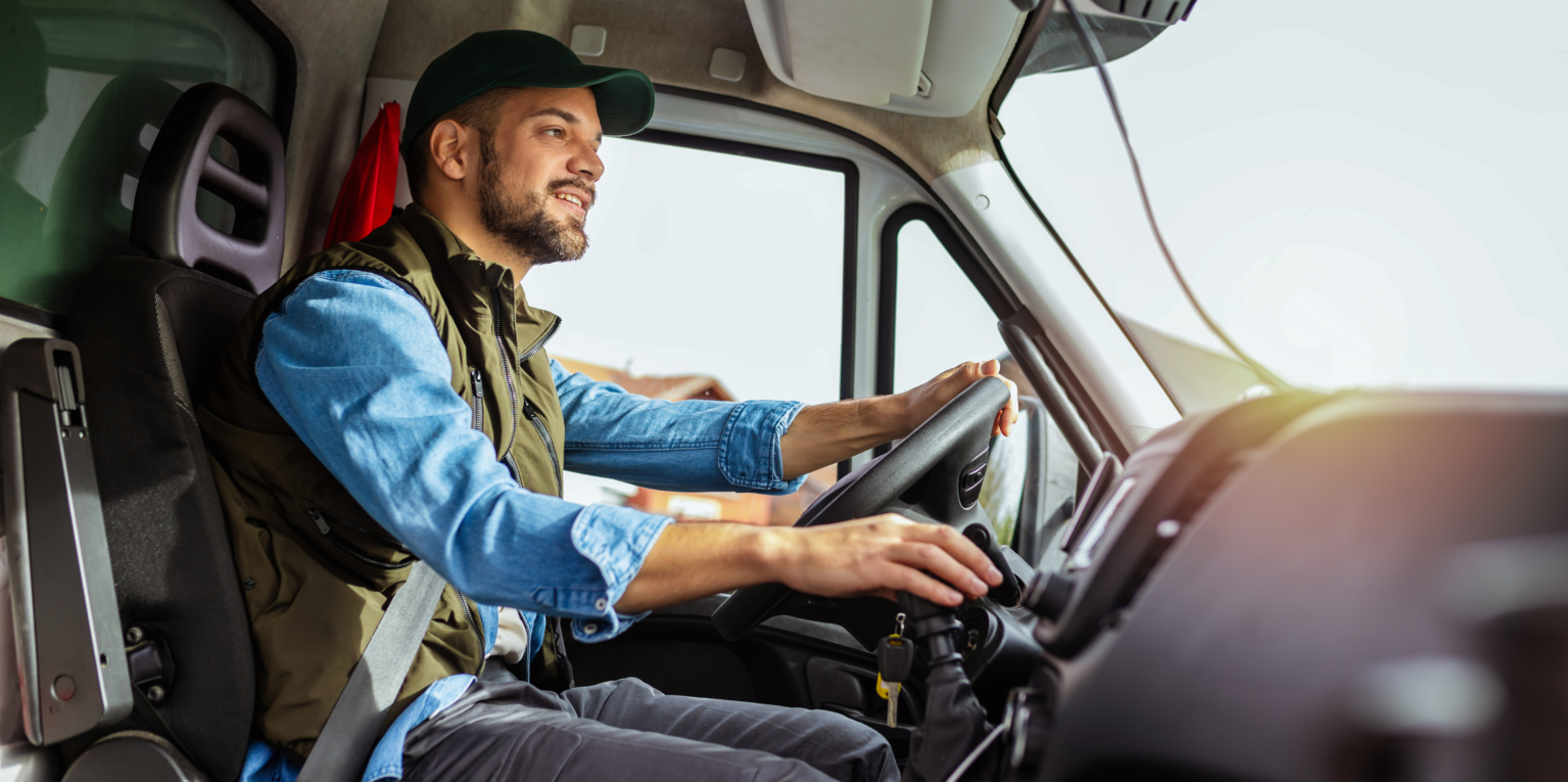 Young handsome man working in towing service and driving his truck. a man driving a truck