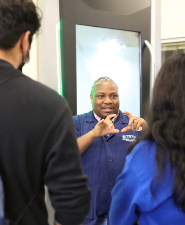 TSTC Precision Machining Technology instructor Deogratias Nizigiyimana demonstrates a CNC (computer numerical control) machine to visitors during an open house event.