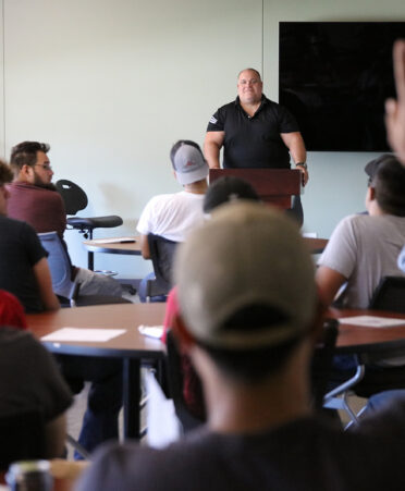 Fairbanks Morse Defense general manager Joe Tomaskovic (standing, center) takes questions from TSTC Diesel Equipment Technology, Electrical Power and Controls, and Industrial Systems students during a recent campus visit.
