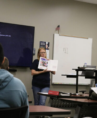 TSTC Career Services associate Jamie Jimenez displays a resource booklet during a recent presentation to TSTC Industrial Systems students.