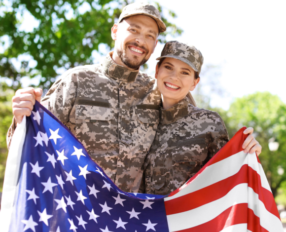 Soldiers holding American flag outdoors.