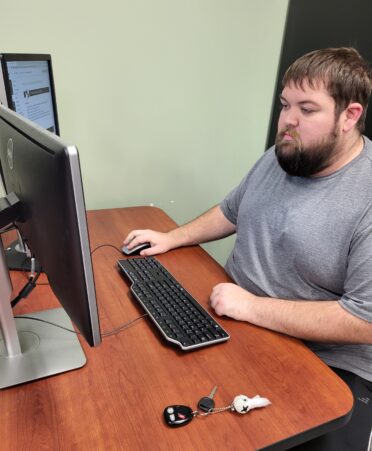 Dillon sits at a computer in the cybersecurity lab.