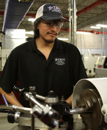 TSTC Precision Machining Technology student Isaac Lopez uses high-speed steel to cut aluminum on a lathe machine during a recent lab session.