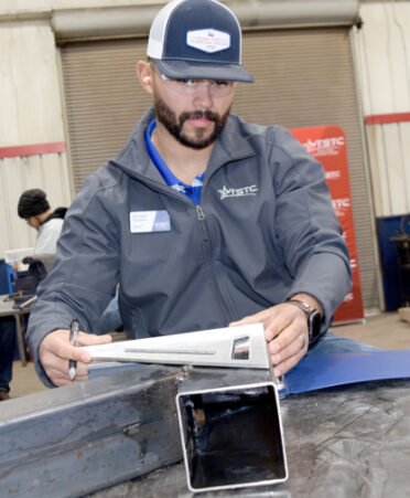 TSTC Welding Technology instructor Salvador Marquez judges one of the projects during the high school welding competition in Breckenridge earlier this month. Marquez, a graduate of TSTC, is an instructor at the Breckenridge and Brownwood campuses.