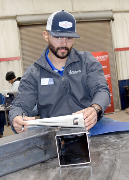 TSTC Welding Technology instructor Salvador Marquez judges one of the projects during the high school welding competition in Breckenridge earlier this month. Marquez, a graduate of TSTC, is an instructor at the Breckenridge and Brownwood campuses.