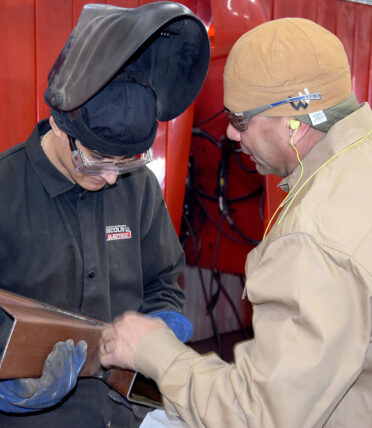 aniel Aguirre (right), a TSTC Welding Technology instructor in Brownwood, discusses Rafael Castro’s project during a high school welding competition at the Breckenridge campus earlier this month.