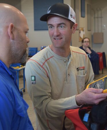 TSTC Electrical Power and Controls student Sean Spear (right) shows classmate Matthew Perkins some of the equipment he was issued when he began his internship with Power Engineers.