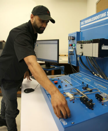 TSTC Mechatronics Technology student Jeremy Gaytan creates a programmable logic controller (PLC) program on an Amatrol troubleshooting system during a recent lab session.