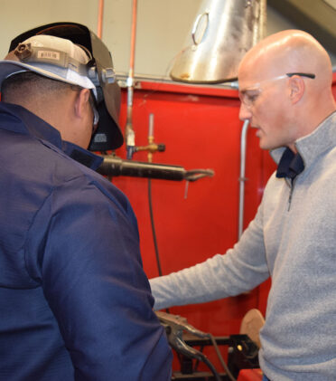 Scott Wallerman (right) talks with a Texas FFA Area IV competitor during the agricultural and engineering career development contest at TSTC’s Abilene campus. Wallerman, who works for Broadwind Heavy Fabrications, was the certified welding inspector for the event.