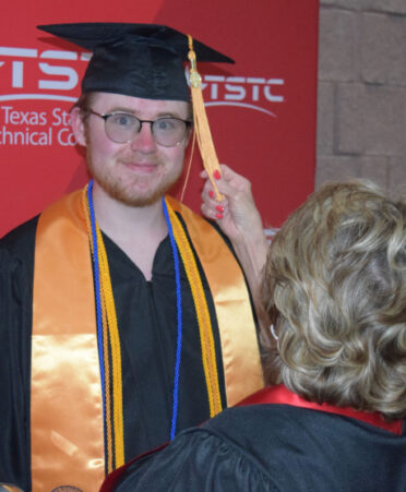 Joni Coons (right), TSTC’s leadership coach for TSTC Residence Life and Engagement, adjusts the tassel of Brian Holder, a graduate of the Wind Energy Technology program, prior to the Spring Commencement ceremony on Thursday, April 27.