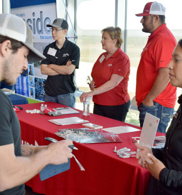 TSTC Industrial Systems student Arend Bali (left) takes notes while talking to Silvia De La Garza, a recruiting coordinator with Expanse Electrical Co., during TSTC’s Industry Job Fair on Thursday, April 13.