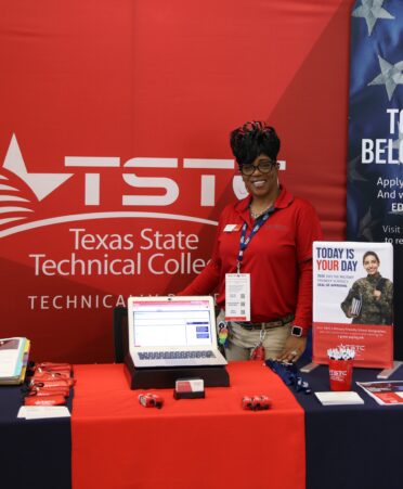 Sandrine Casimir stands behind a table promoting the Veteran Recruitment program