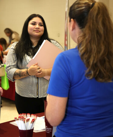 Judith Sauceda (left), a TSTC Associate Degree in Nursing student, discusses patient care with Marisa Cardenas Guerra, director of nursing for Harlingen Nursing and Rehabilitation Center, at the recent TSTC Nursing Expo in Harlingen.