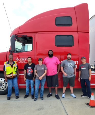 Students and Instructor stand in front of semi