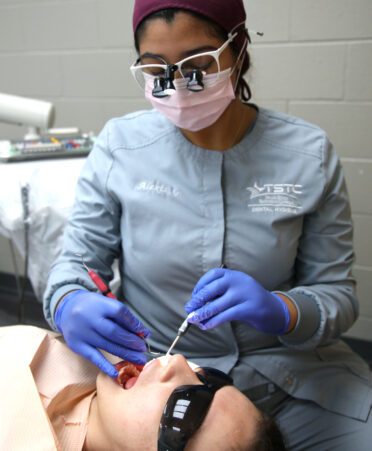 TSTC Dental Hygiene student Alexis Garcia (right) uses a scaler instrument to practice cleaning teeth on Hilary Navarro, an incoming Dental Hygiene fall semester student, during a recent lab session.