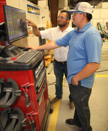 TSTC Auto Collision and Management Technology instructor Jesus Reyna (left) explains a wheel alignment process to student Jesus Padron during a recent lab session.