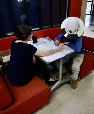 TSTC Career Services coordinator Jena Corley helps an Electrical Lineworker and Management Technology student fill out paperwork to receive his tickets for the upcoming summer commencement exercise. (Photo courtesy of TSTC.)