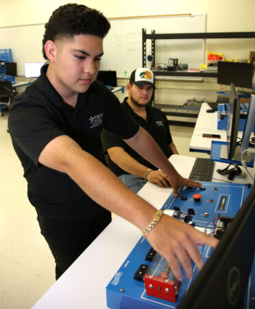 TSTC Mechatronics Technology students Manrique Parra (left) and Michael Zamora create a control logic program that will run a motor using timers on a delay during a recent lab session.