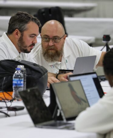 Two students huddle together to discuss strategy during SkillsUSA competition.