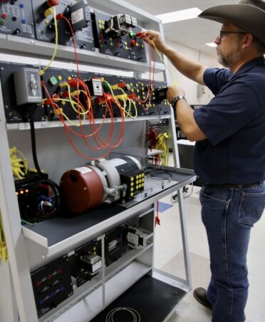 TSTC Industrial Systems instructor John Fondren builds a three-wire start-stop station, the building block of a motor control circuit.