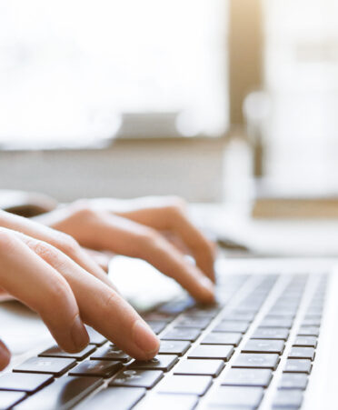 hands typing on a keyboard