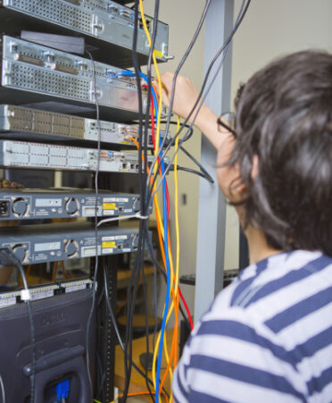 person in striped short working with wires