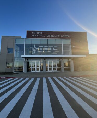 Shows front of TSTC's North Texas campus with a light flare from the sun on the right side.