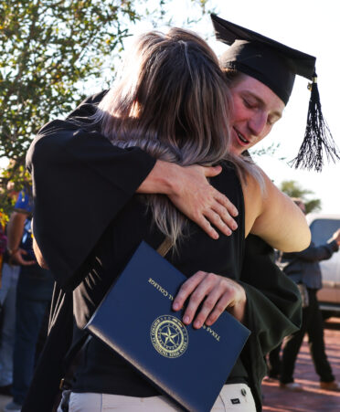 A TSTC Marshall campus graduate hugs a family member in joy post ceremony. (Photo courtesy of TSTC.)