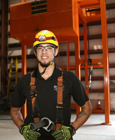 TSTC Wind Energy Technology student Andrew Garza stands next to a practice climbing area that is used for a self-rescue training exercise.