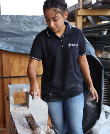 Victoria Garcia, a TSTC Building Construction Technology student, prepares a layer of concrete while training for the SPEC Mix Bricklayer 500 South Texas Regional Series event.