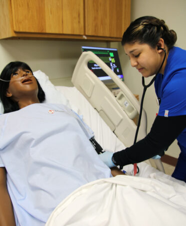 TSTC Vocational Nursing student Martha Arellano uses a blood pressure cuff to monitor the vital signs and blood pressure of a medical manikin during a recent lab session.