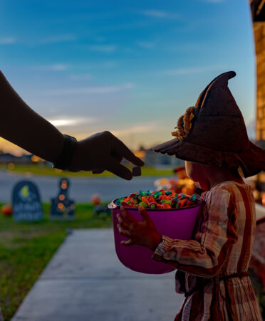 Little girl in witch hat wth jack o latern