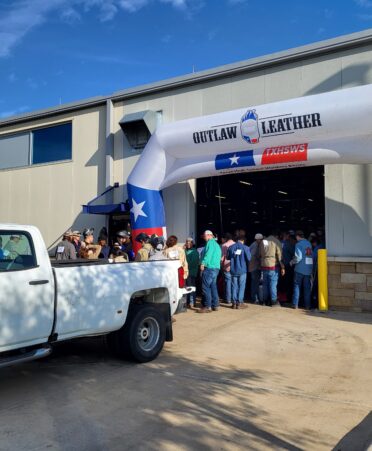 Students line up behind a white truck and under a white blow up archway