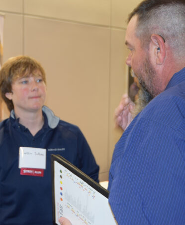 female with name tag talking to man in blue shirt
