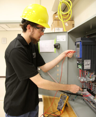 TSTC Mechatronics Technology student Chipman Falls troubleshoots a forward and reverse motor system during a recent lab session.