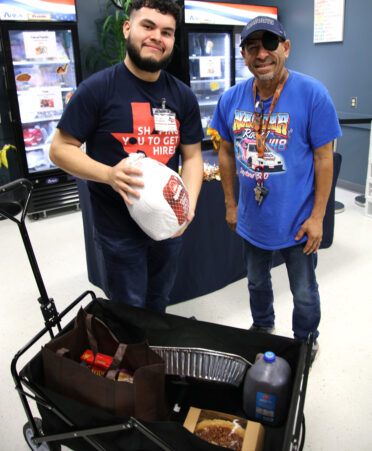 Daniel Castillo (right), a Building Construction Technology student, accepts a holiday meal kit from Robert Barrajas, a member of the TSTC Advocacy and Resource Center team at the Harlingen campus.