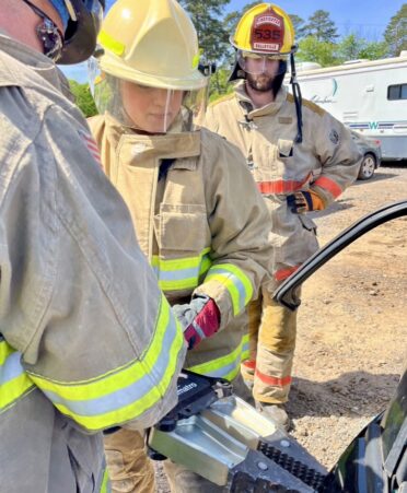 Veronique Ramirez, a TSTC Student Services representative, uses the Jaws of Life to pry open a car door while training as a volunteer firefighter. (Photo courtesy of Véronique Ramirez.)