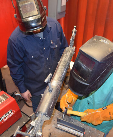 two people working in a welding booth