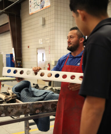 A TSTC Auto Collision and Management Technology instructor (left) shows visiting high school students a class project, a sun visor for a 1927 Durant automobile that was fabricated by his students, during the college's Discovery Day on Thursday, Nov. 30.