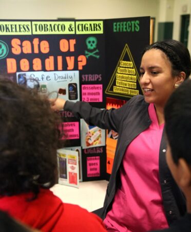 Photo caption: TSTC Dental Hygiene student Kristy Rocha (right) talks about the harmful effects of tobacco in a recent community outreach presentation to fifth grade students at Lyford Elementary School. (Photo courtesy of TSTC.)