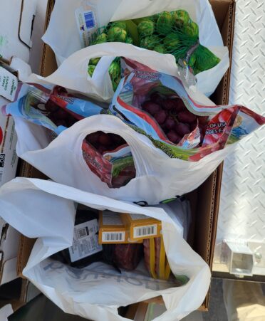 Three white bags hold food in a box.