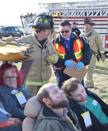 group of people looking at wrecked vehicle